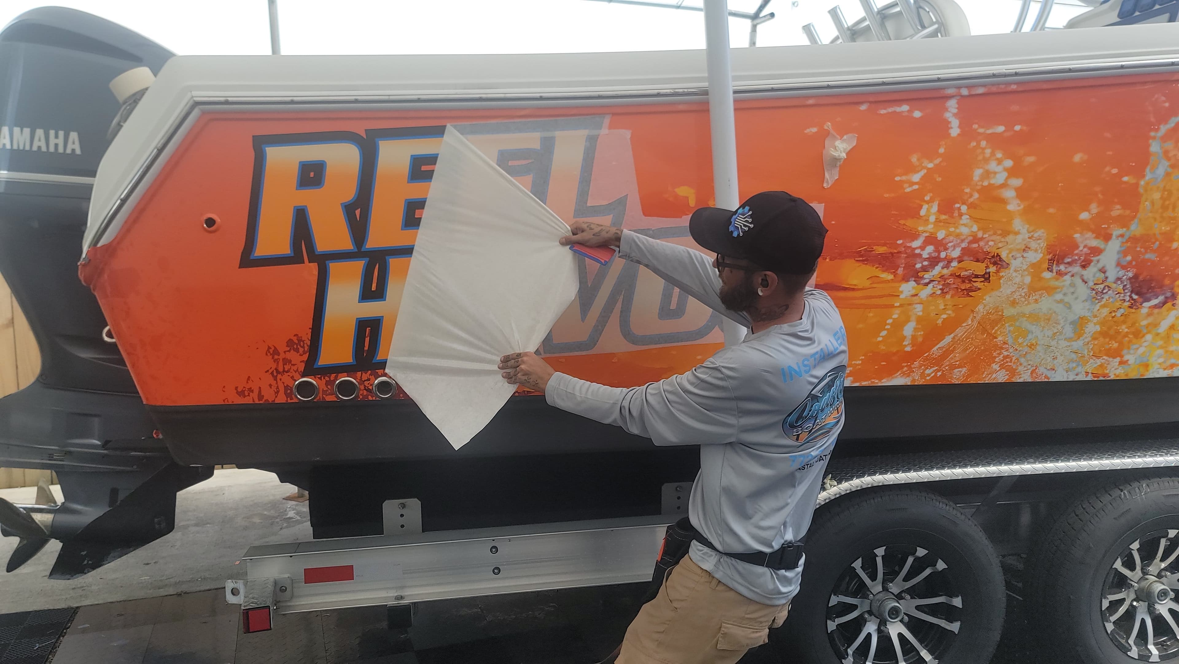 Professional boat wrap installation on the water